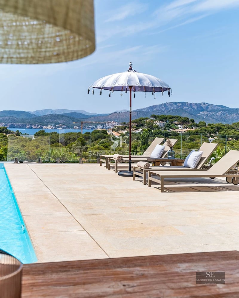 View of a luxurious modern villa with infinity pool, expansive terraces, and panoramic sea views. Minimalist and elegant design.