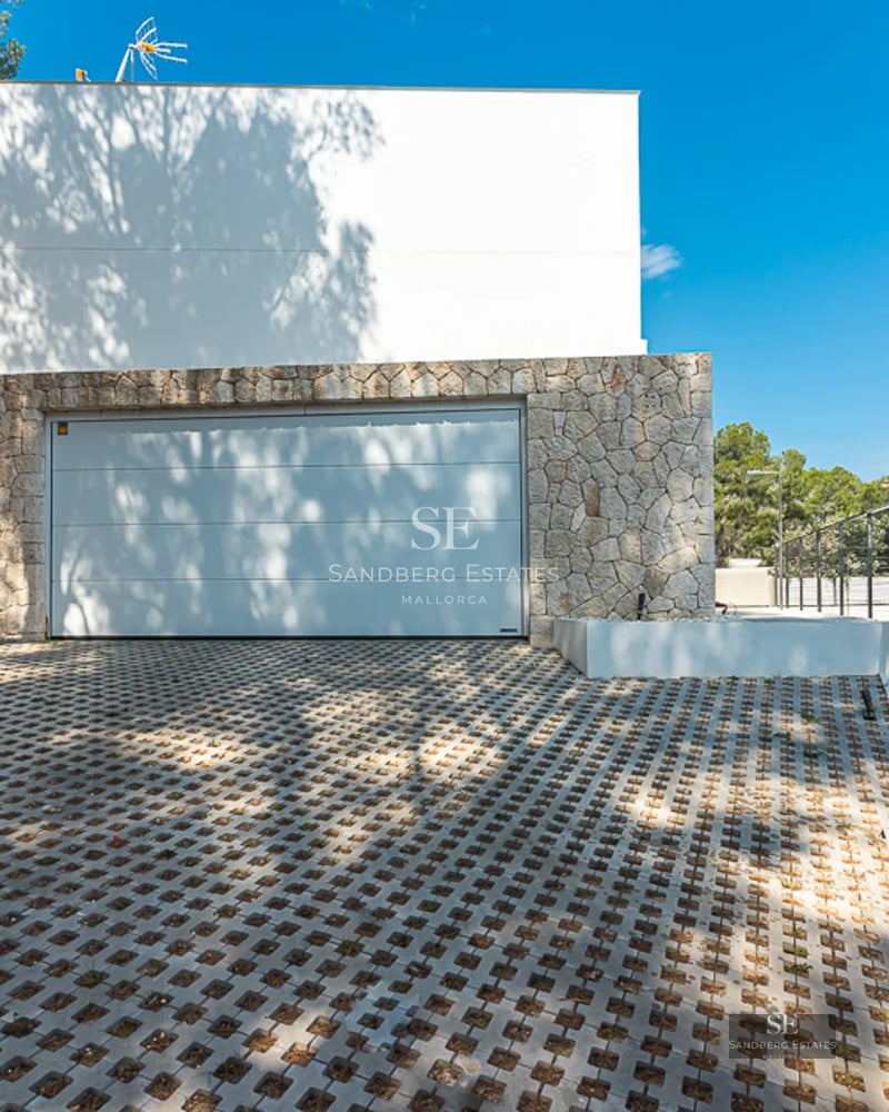 Exterior view of a modern villa with reflecting pool, large windows and elegant landscaping. Contemporary architecture and high-end materials.