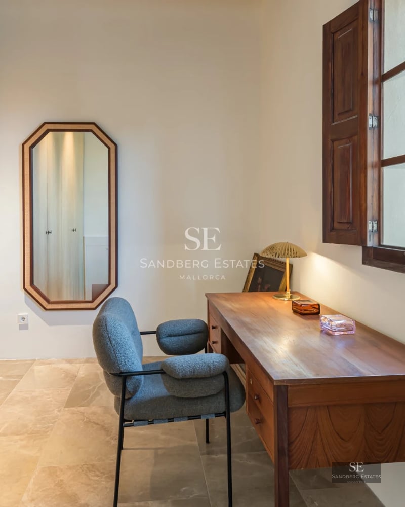 Pool view with wooden deck and armchairs. Modern architecture, natural lighting, lush vegetation and blue sky.