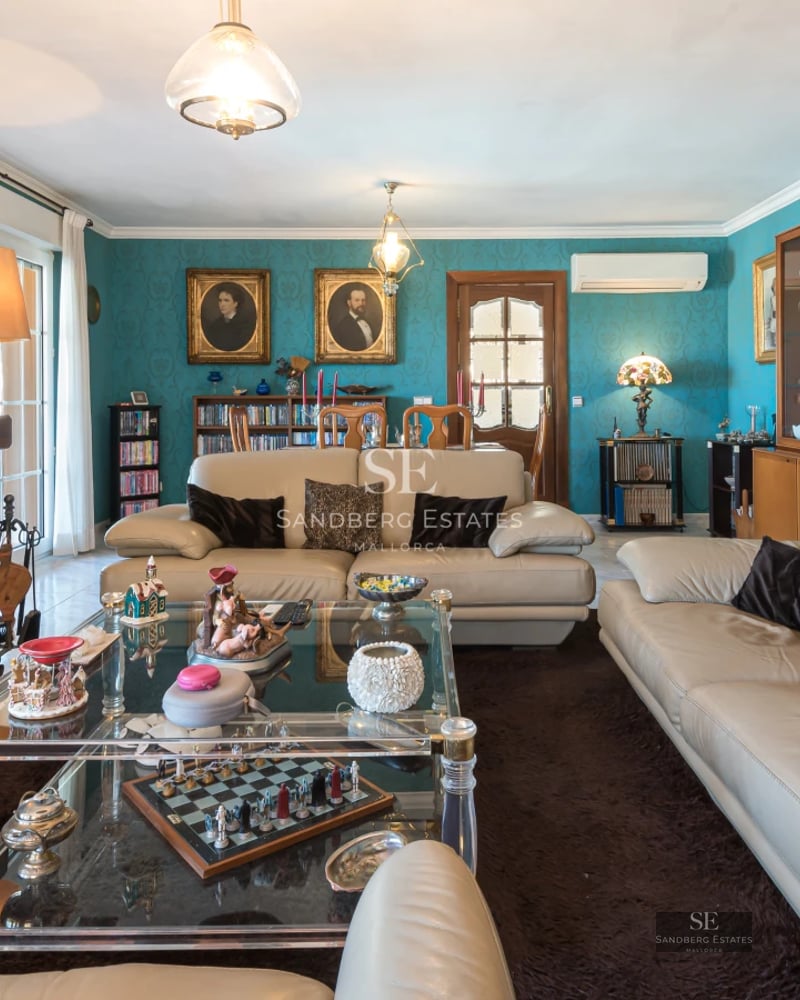 Spacious, bright living room with window walls, light wood floors, modern fireplace and view of pool and garden. Minimalist design.