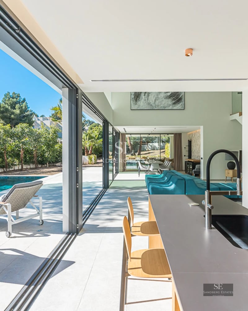 Vue d'une villa moderne avec piscine à débordement, transats et jardin paysager. Design minimaliste avec de grandes baies vitrées et une lumière naturelle abondante.