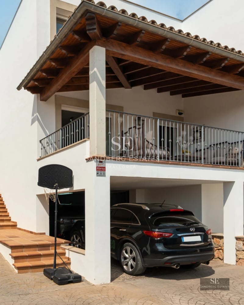 Aerial view of a modern villa with a pool, lush garden, and minimalist architectural design featuring large windows.