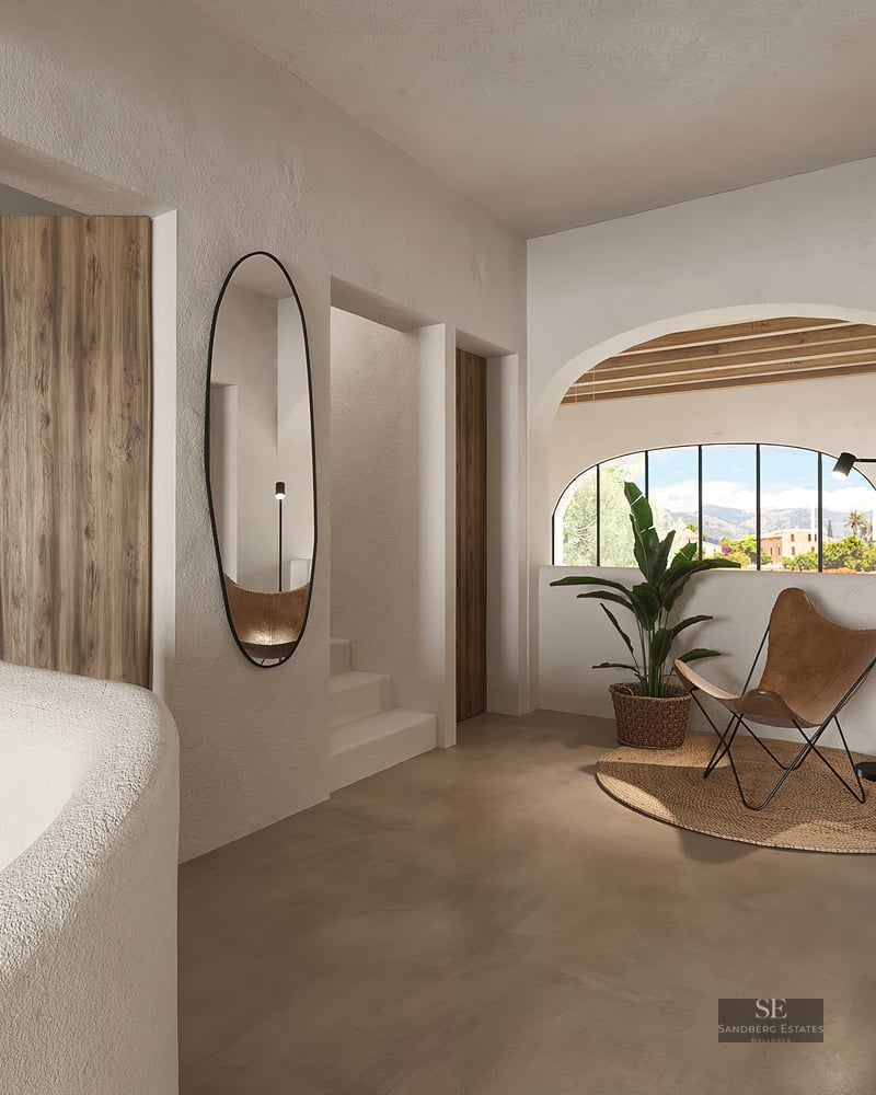Modern hallway with textured walls, leather butterfly chair, oval mirror, and arched window with mountain views.