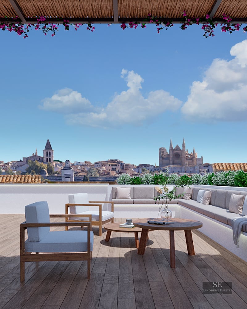 Luxury rooftop terrace with wooden deck, comfortable lounge seating, fireplace, and panoramic views of a city cathedral.