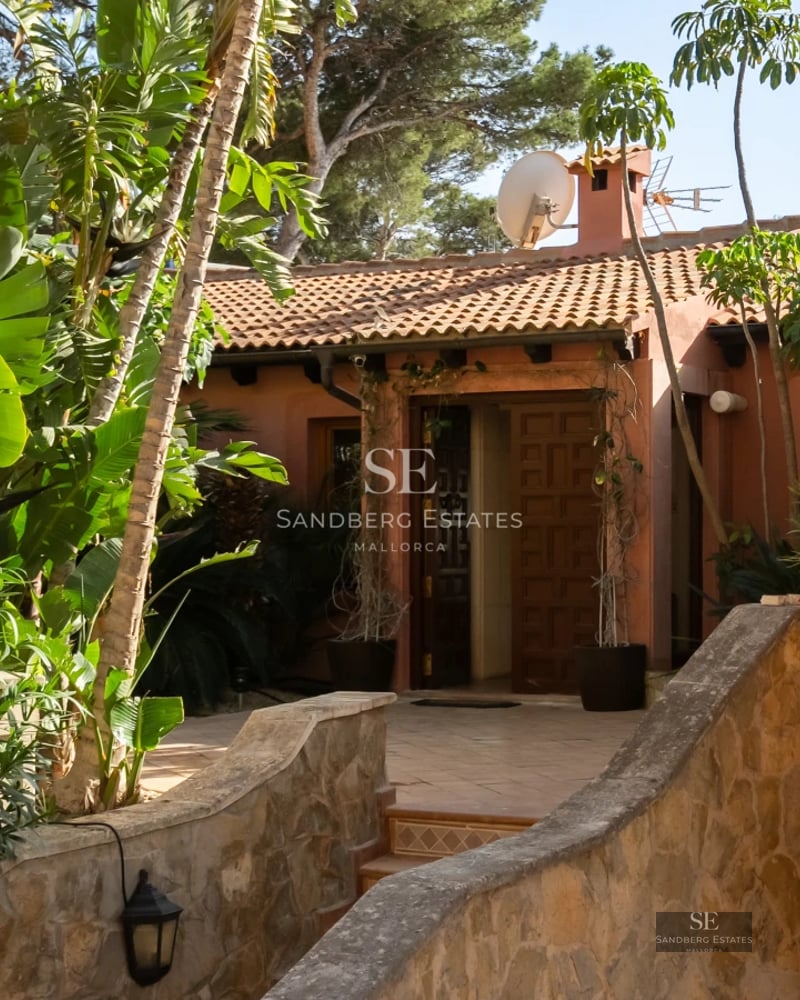 Exterior view of a modern villa featuring an infinity pool, lush garden, and minimalist architecture. Facade with large windows and clean lines.