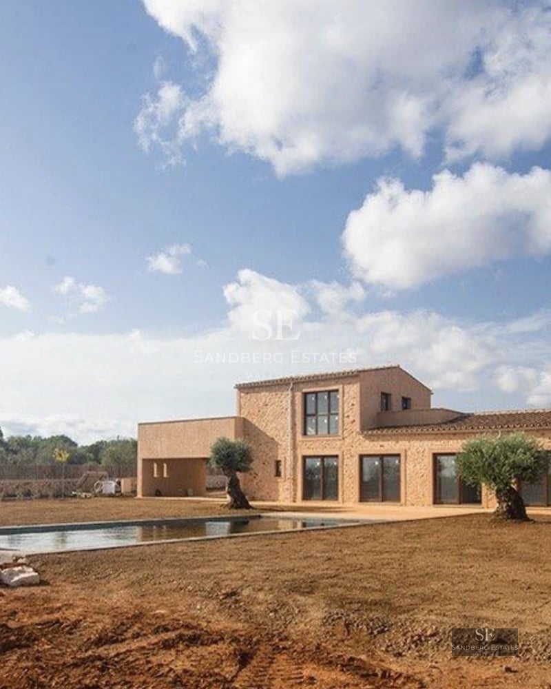 Exterior view of a modern villa with pool, surrounded by greenery. Minimalist architecture, large windows, and luxury finishes.