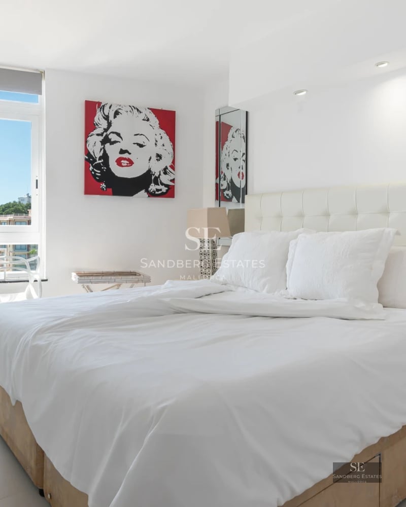 Expansive infinity pool surrounded by green lawn and modern architecture featuring large windows and a wooden facade.