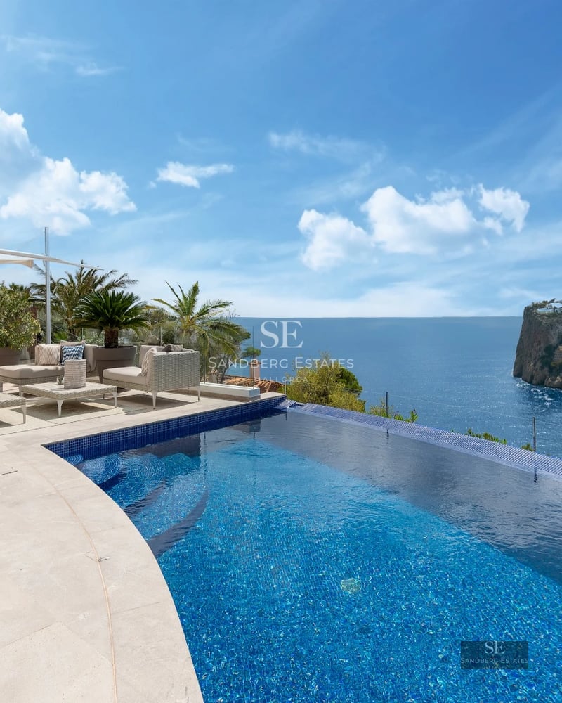 Spacious balcony with panoramic sea views. Glass railing, tiled floor. Modern and elegant design.