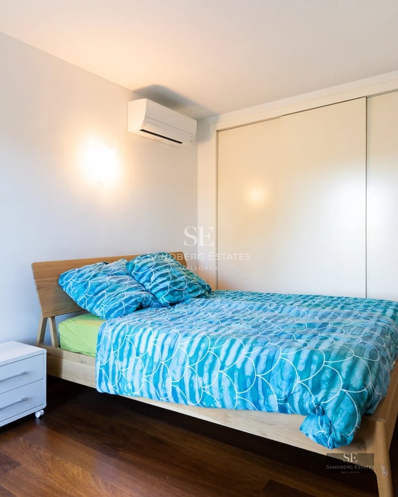 View of a pool surrounded by lush garden with lawn and trees. Modern architecture featuring large windows.