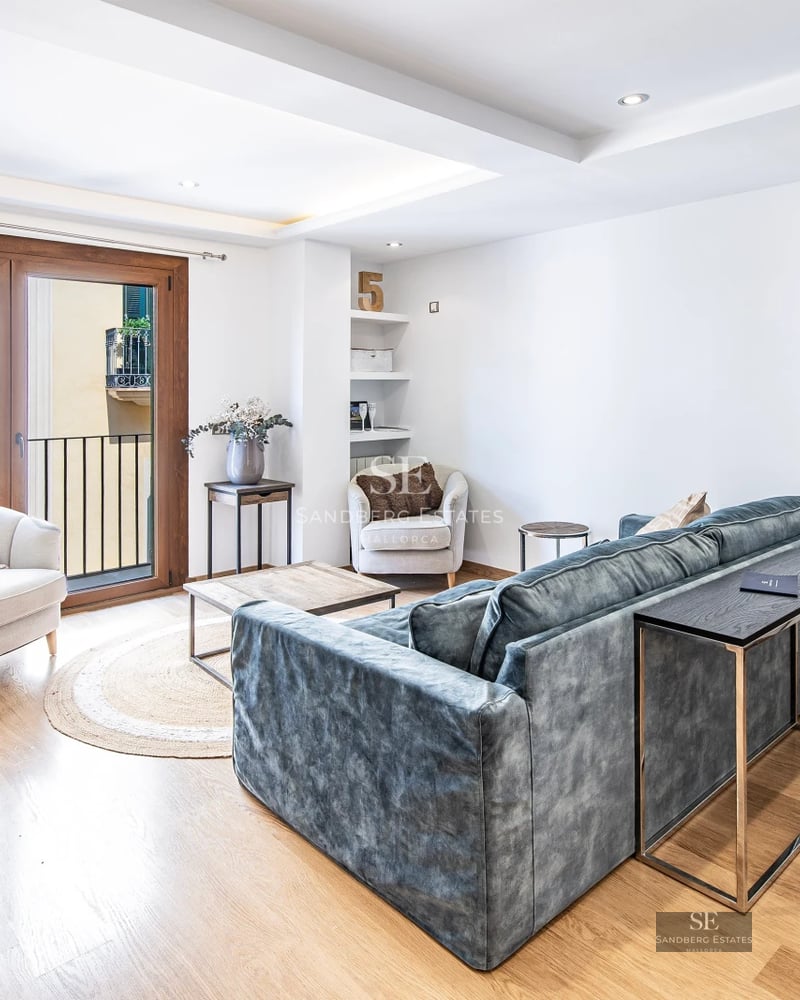 View of a modern pool with elegant furniture, surrounded by gardens and a minimalist house with large windows.