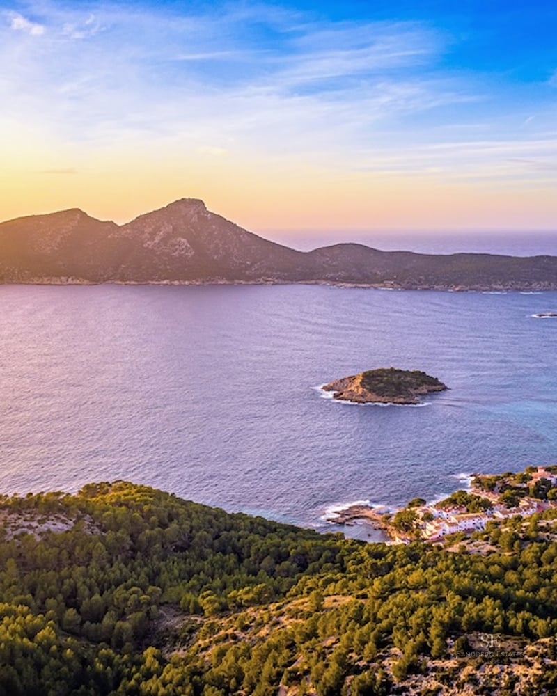 Aerial view of the Mediterranean Sea and Dragonera Island at sunset with golden light across the coastline.