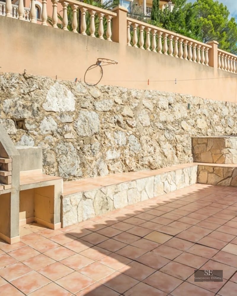 Aerial view of a luxurious house with a pool, manicured garden, and modern architectural design. Abundant natural lighting.