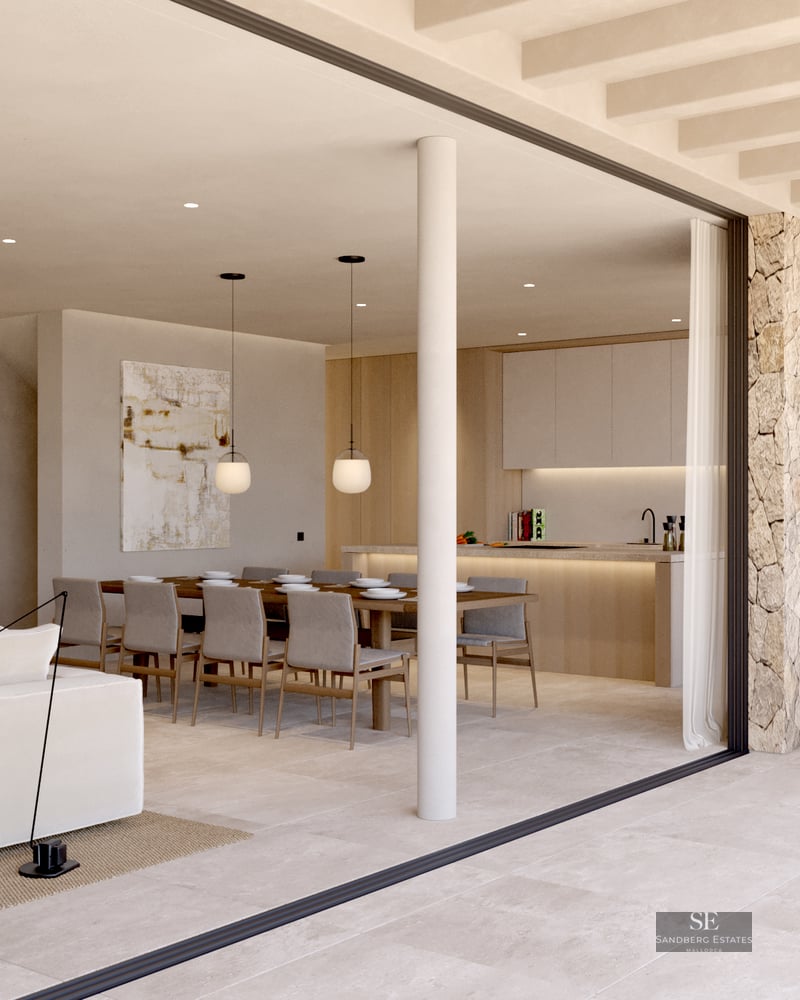 Spacious indoor living room with white sofa flowing into an outdoor terrace with dining and kitchen areas.