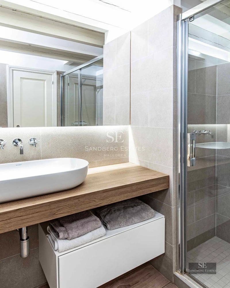 Spacious view of modern living room. Large windows illuminate the space with elegant sofas, coffee table and outdoor access.