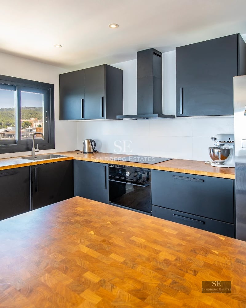 Spacious balcony with panoramic sea views. Modern outdoor furniture, wooden floor, glass railing.