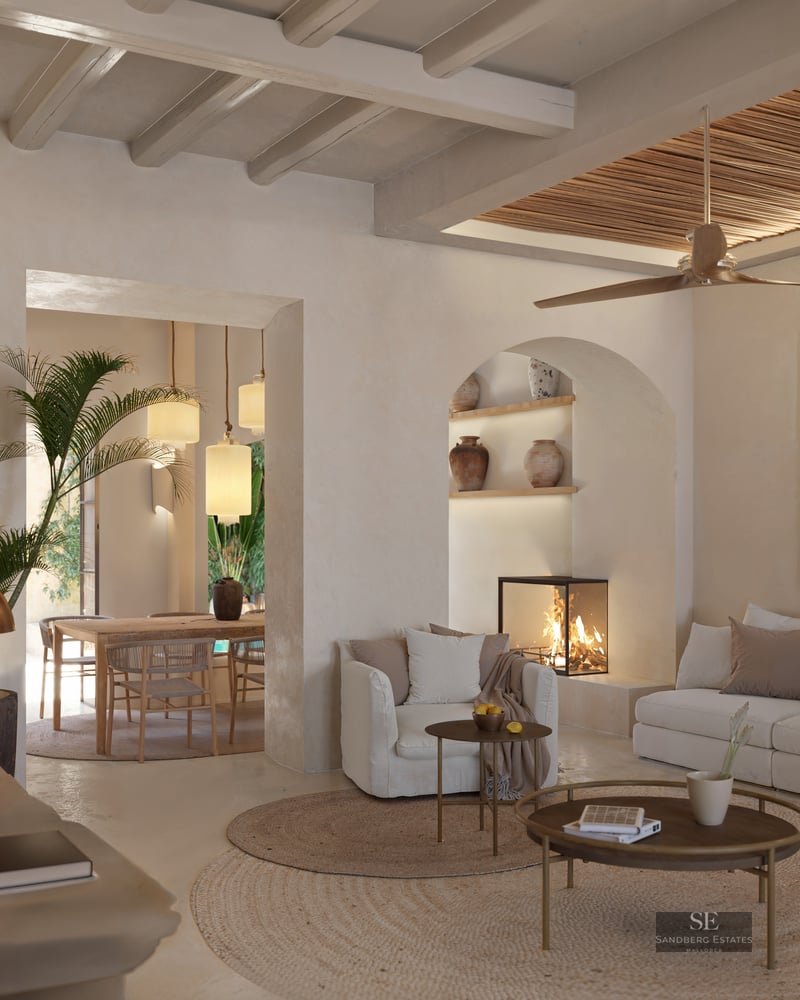 Elegant living room with white sofas, wooden beams, a glass fireplace, and an arched niche with decorative vases.
