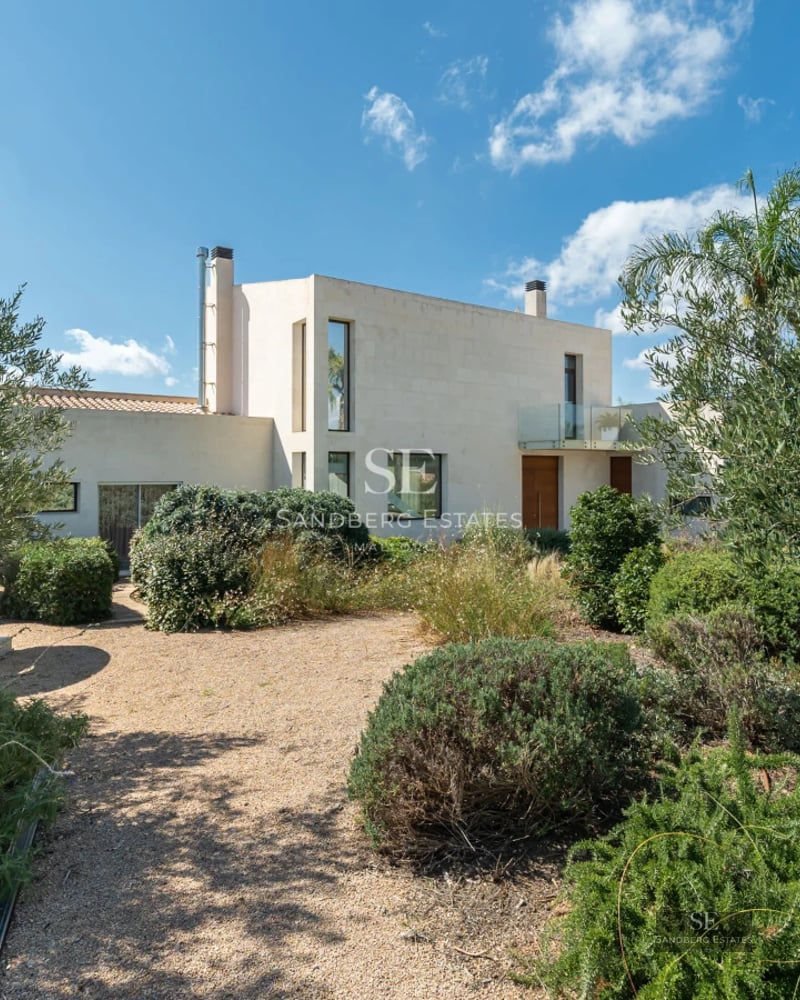 Spacious balcony with sea view, modern and elegant furniture. Wooden floors, glass railing, and comfortable seating area.