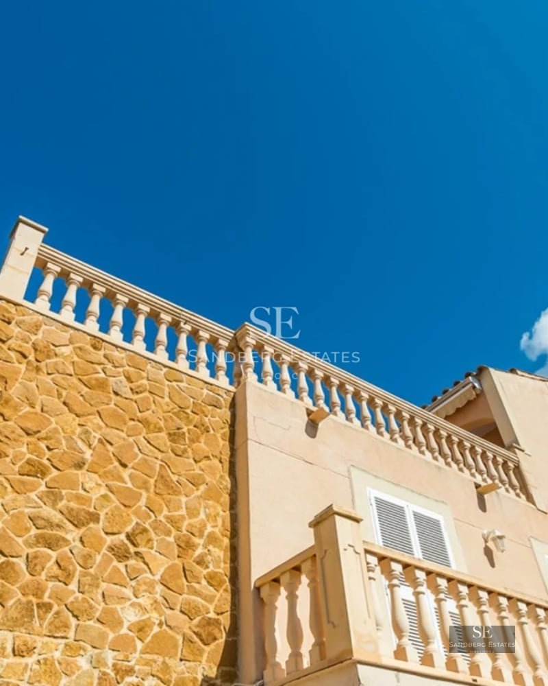 Bright living room with sea view, glazed balcony, light wood floors and minimalist modern decor.