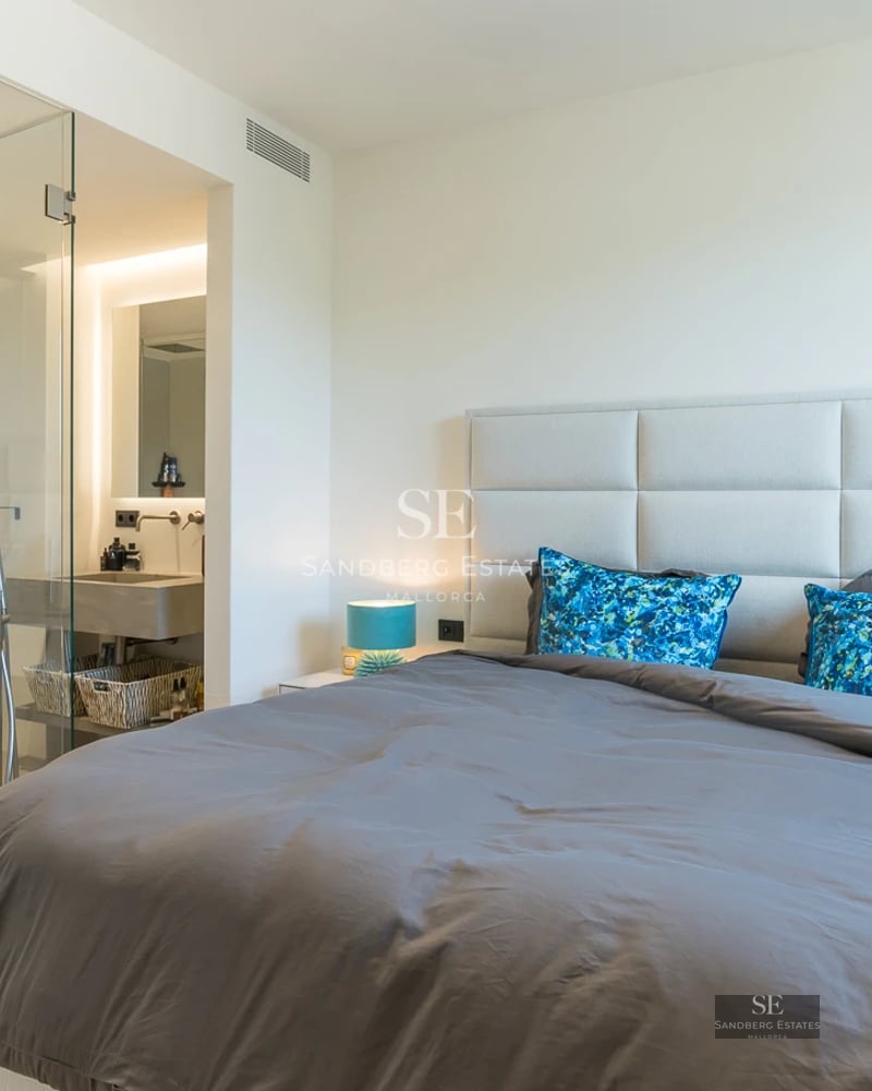 Spacious living room with large windows, natural light, light wood floors, white walls and modern furniture. Exterior view. Bright and airy.