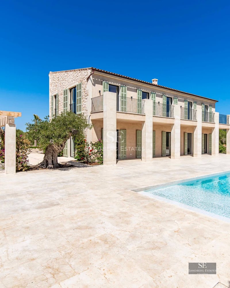 Spacious balcony overlooking the sea, modern furniture, glass railing, wooden floor, and minimalist decor.