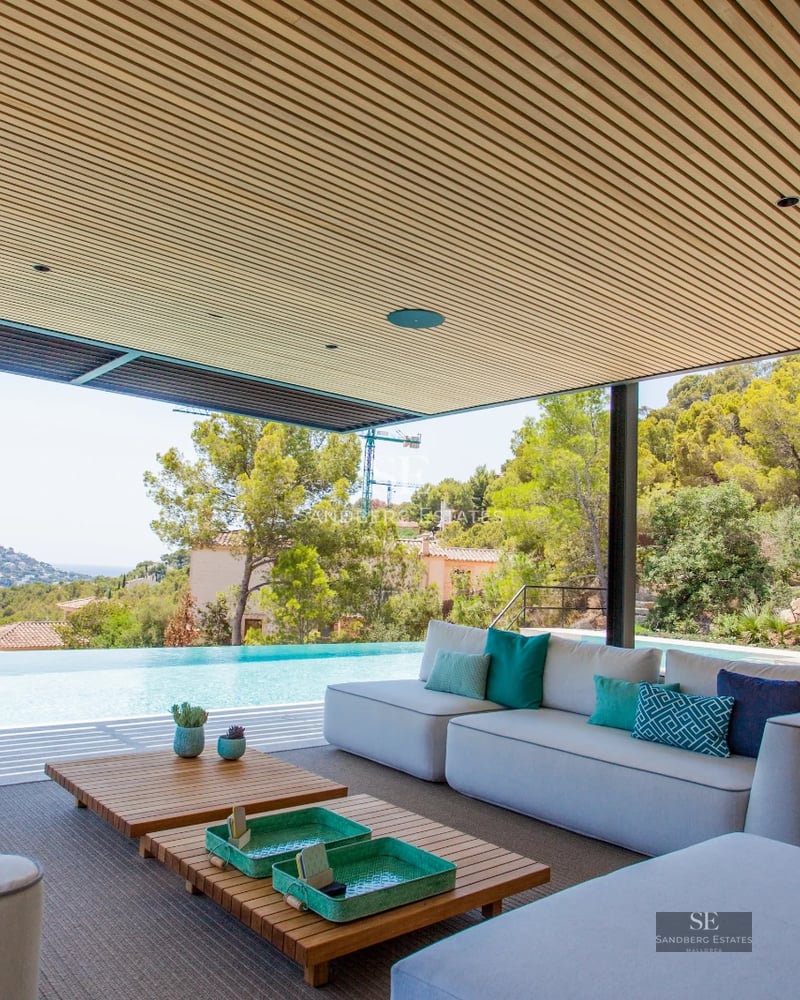 View of a modern swimming pool surrounded by garden and minimalist architecture. Luxury and comfort in a space designed for enjoyment.