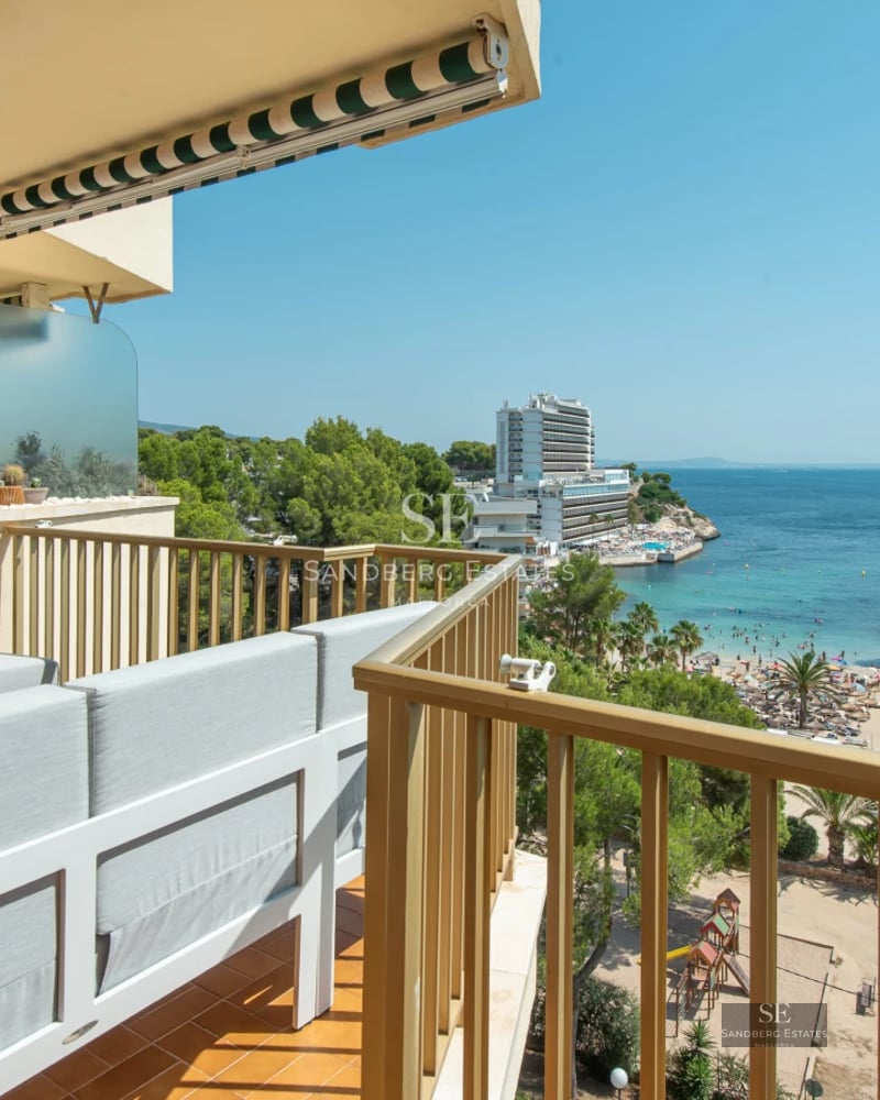 View of modern pool surrounded by vegetation. Minimalist architecture with large windows and manicured landscaping.