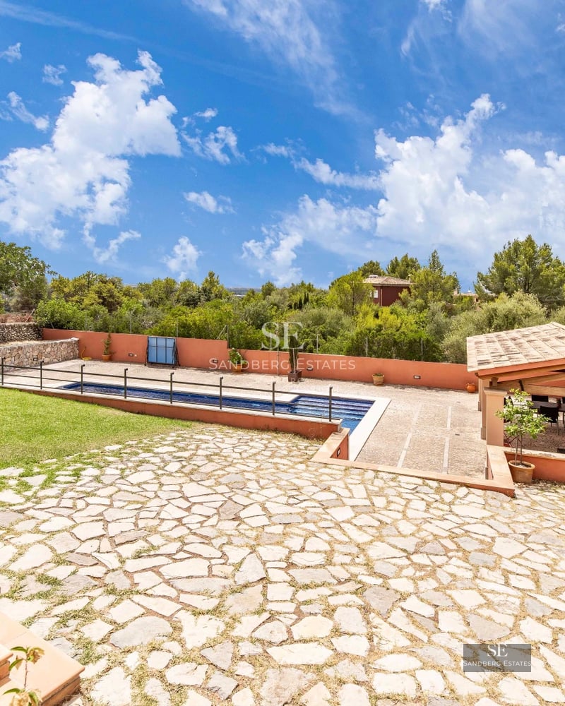 Modern balcony with panoramic views. Glass railing, wood flooring, and stylish furniture. Bright and spacious.