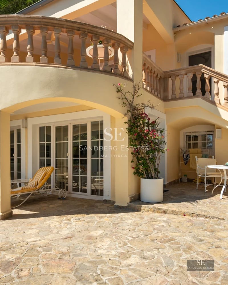 Exterior of a modern villa featuring an infinity pool, lush garden, and expansive terraces with panoramic sea views.