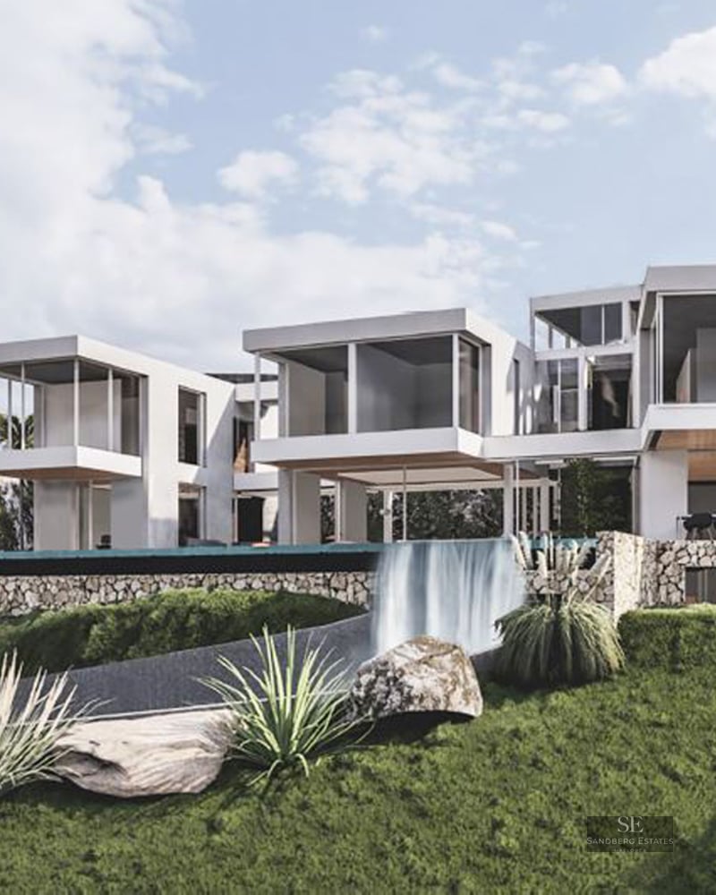 Modern white multi-level villa with cantilevered rooms and an infinity pool waterfall spilling into a landscaped garden.