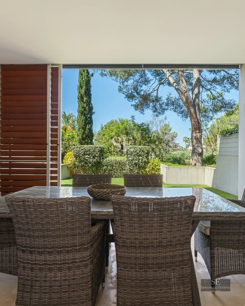Exterior of a modern villa featuring a reflecting pool, expansive glazing, and minimalist landscaping. Warm ambient lighting.