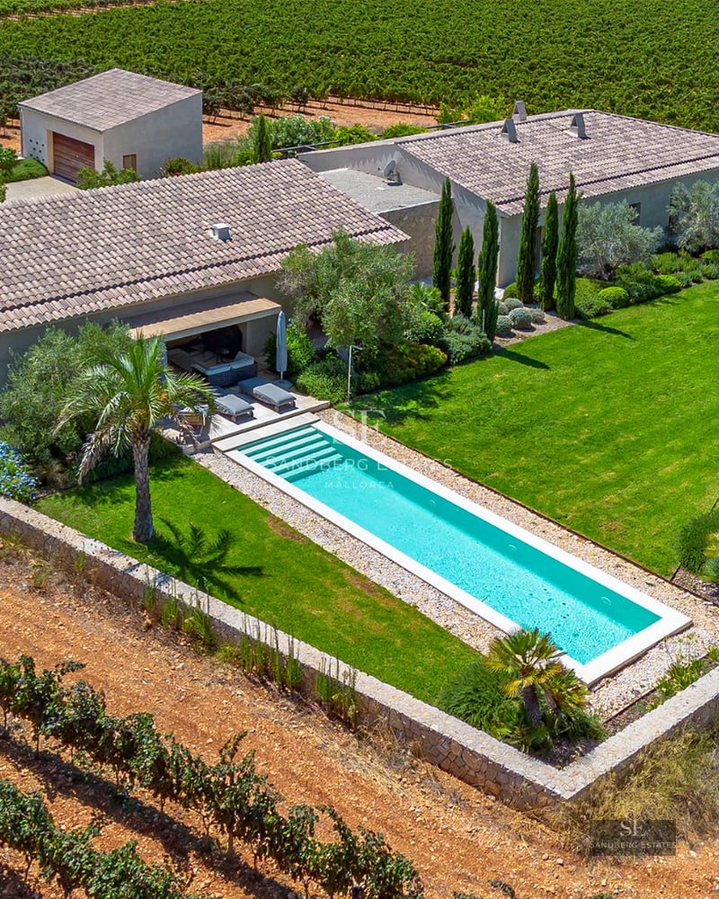 Exterior view of a modern villa featuring a pool, garden, and large windows. Minimalist architecture with natural textures.