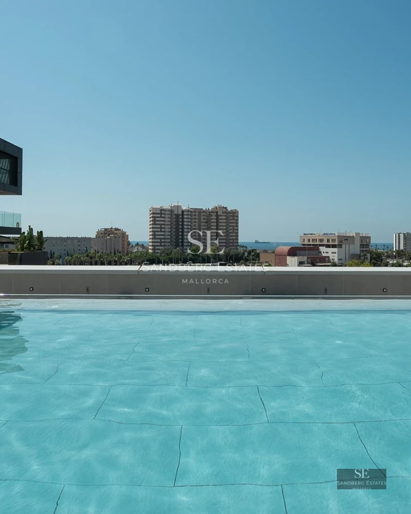 Exterior view of a modern villa featuring an infinity pool, minimalist design, and large windows. Lush garden and blue skies.