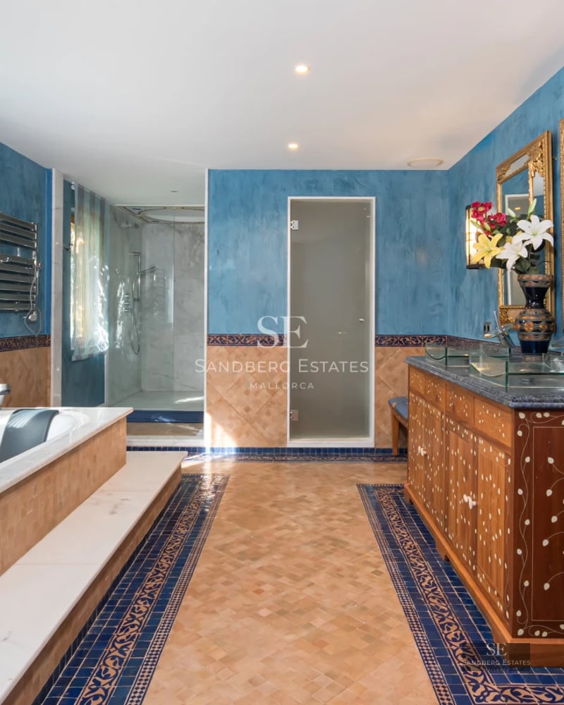 View of infinity pool with lush garden and modern architecture. Large windows reflect natural light. Peaceful and elegant landscape.