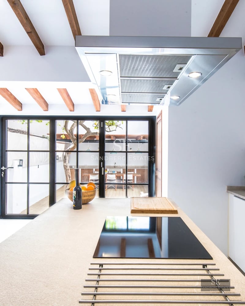 Spacious living room with natural light, large windows, a fireplace, and modern furnishings. Light wood floors and a neutral color palette.