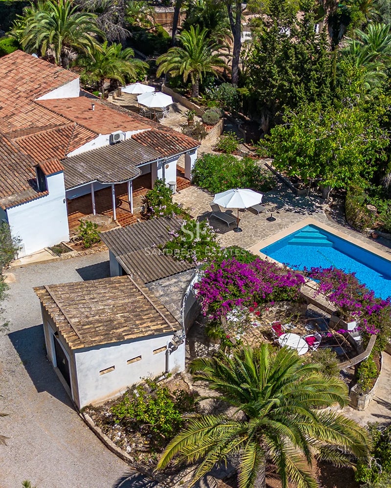 Exterior view of a modern villa with an infinity pool, large garden, and minimalist design. Warm ambient lighting.