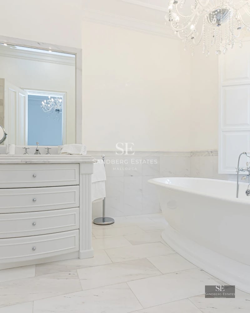 View of infinity pool with glass edge and lush garden. Modern architecture with clean lines and manicured landscaping.