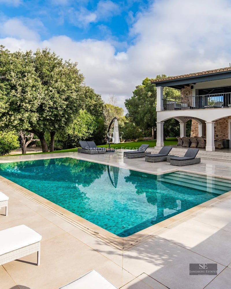 Exterior view of modern villa featuring infinity pool, expansive terraces, and lush garden. Minimalist architectural design with clean lines.