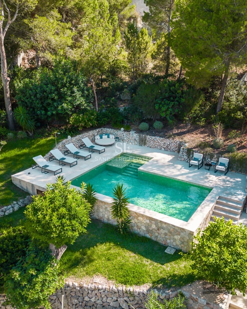 Modern balcony with glass railing, sea view, stylish furniture and wooden floor. Minimalist design and natural light.