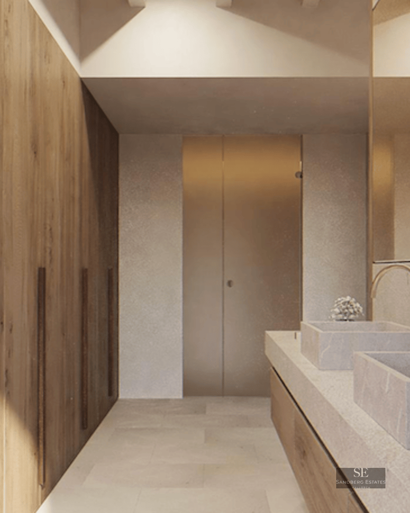Modern bathroom featuring dual stone basins, gold faucets, and floor-to-ceiling natural wood cabinetry.