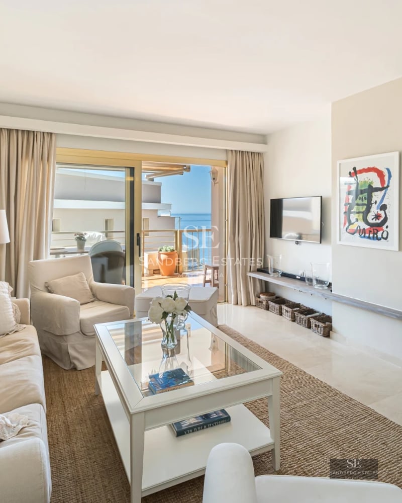 View of a luxurious modern villa with infinity pool, stylish loungers, and lush garden. Contemporary architectural design.