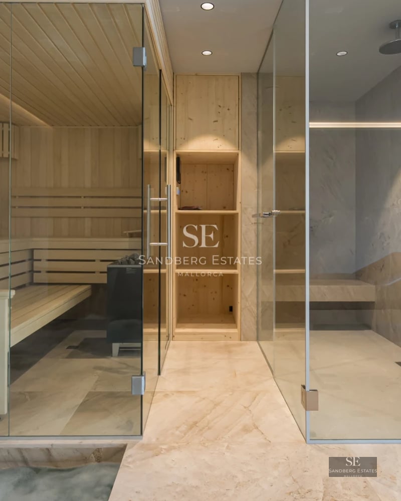 Spacious living room with large windows, light wood floor, modern sofa, and panoramic sea view. Minimalist and elegant design.