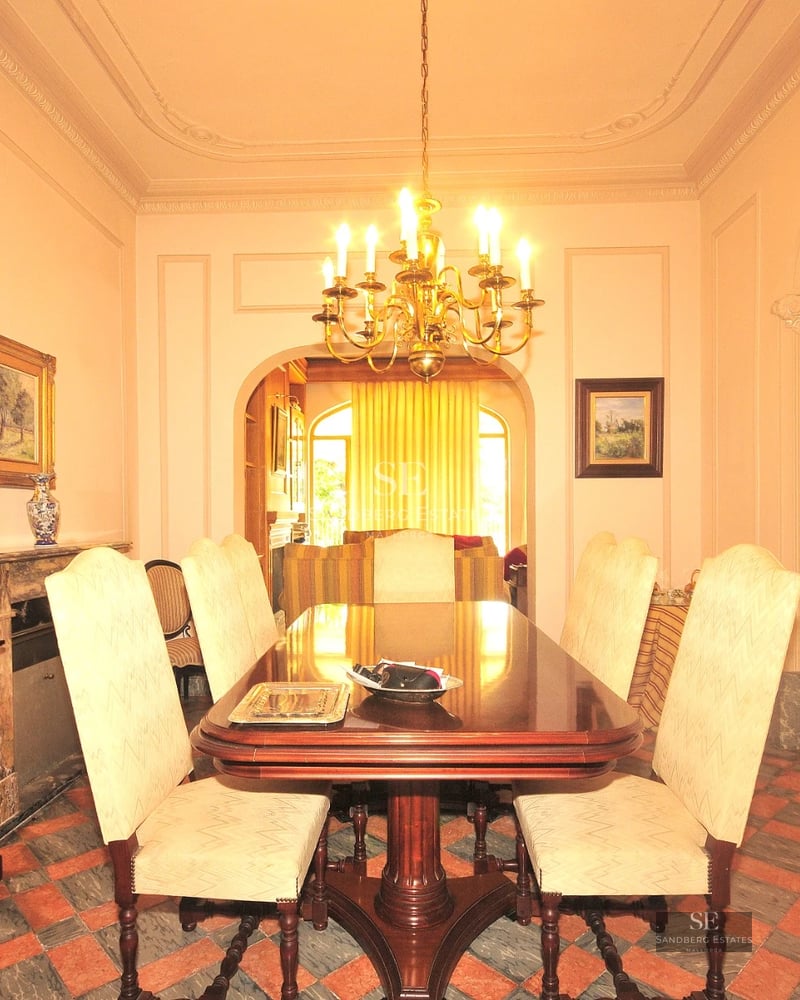 Exterior view of a modern villa featuring an infinity pool, wooden deck, large glass windows, and lush garden. Minimalist architecture.