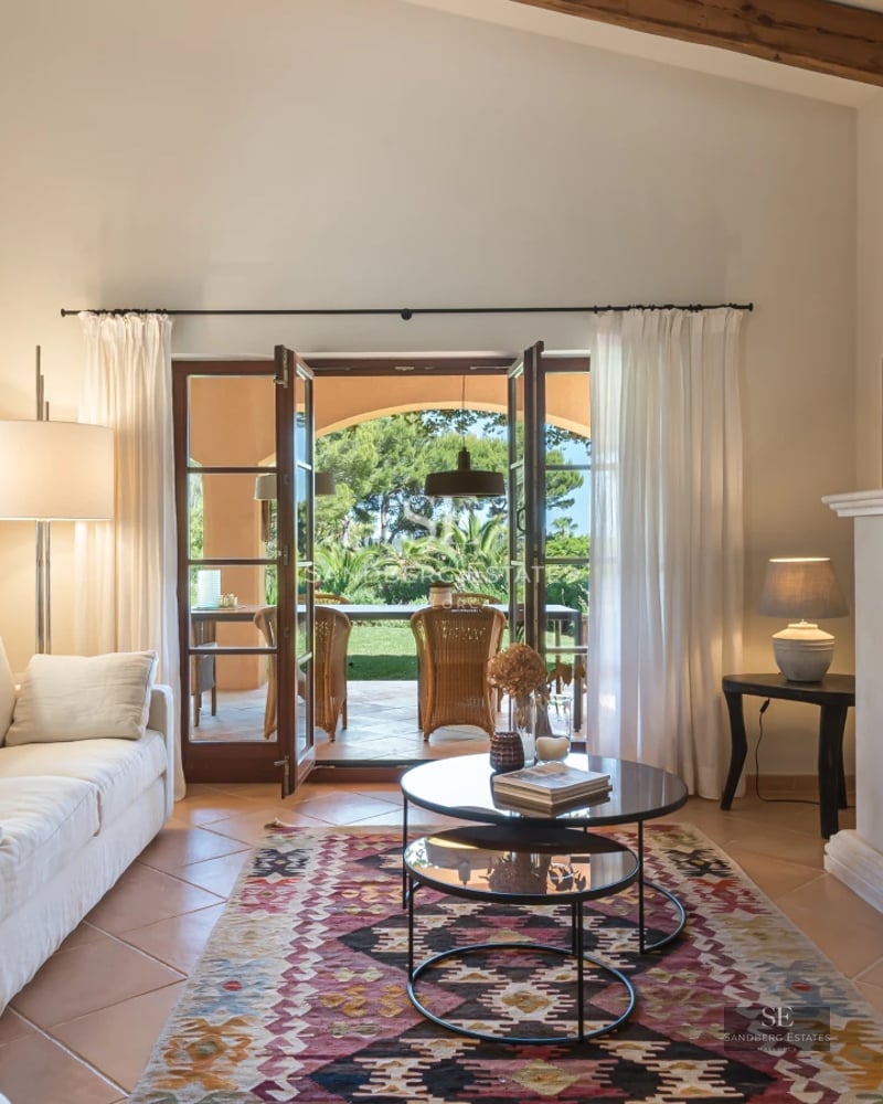 Spacious outdoor area featuring a modern pool, seating area, lush greenery, and elegant architectural design. Natural lighting.