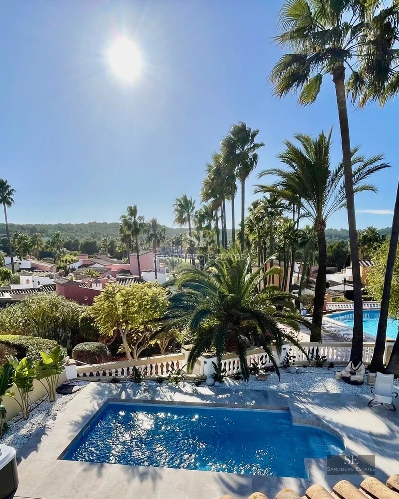 Exterior of a modern villa featuring an infinity pool, landscaped garden, and spacious terraces. Contemporary architecture with large windows.