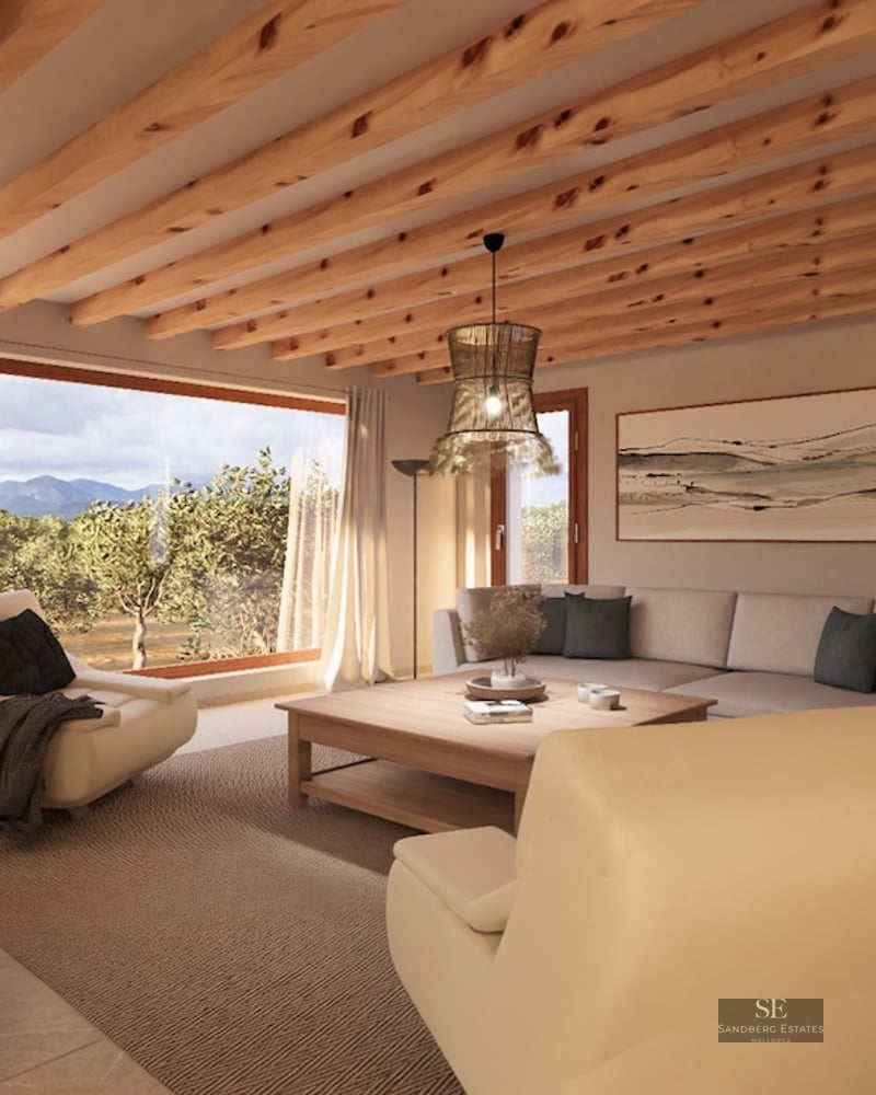 Modern living room featuring exposed wood ceiling beams, cream sofas, and a large window overlooking mountains.