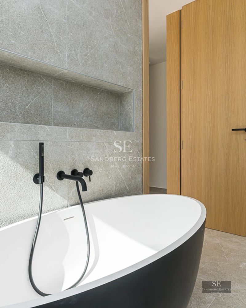 Vaste terrasse avec piscine à débordement et vue panoramique sur la mer. Design moderne avec plancher en bois et mobilier élégant.