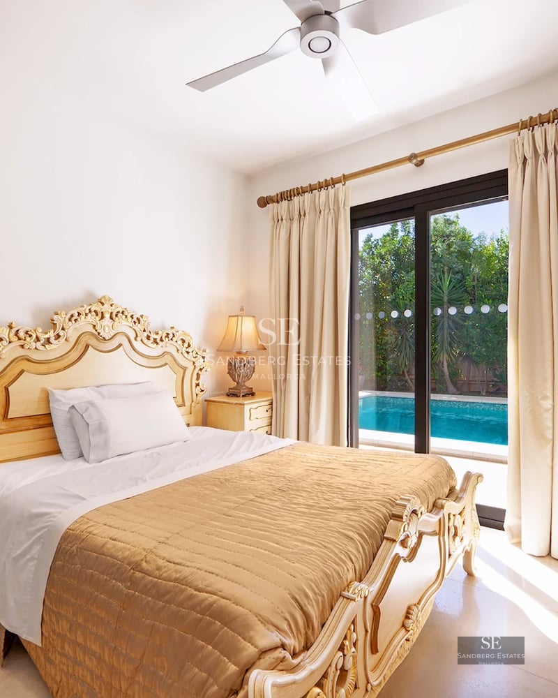 Spacious living room with fireplace, large windows, balcony with view. Modern design, wood floors, and natural light.