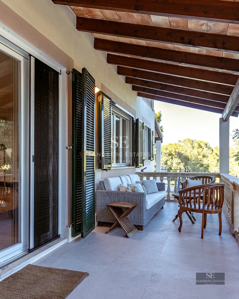 View of a luxurious villa with infinity pool, lush gardens, and modern architectural design. Large windows and sunny terraces.