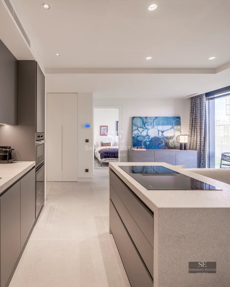 Spacious balcony with sea view. Modern design with wooden floor, glass railing, and stylish furniture. Abundant natural light.