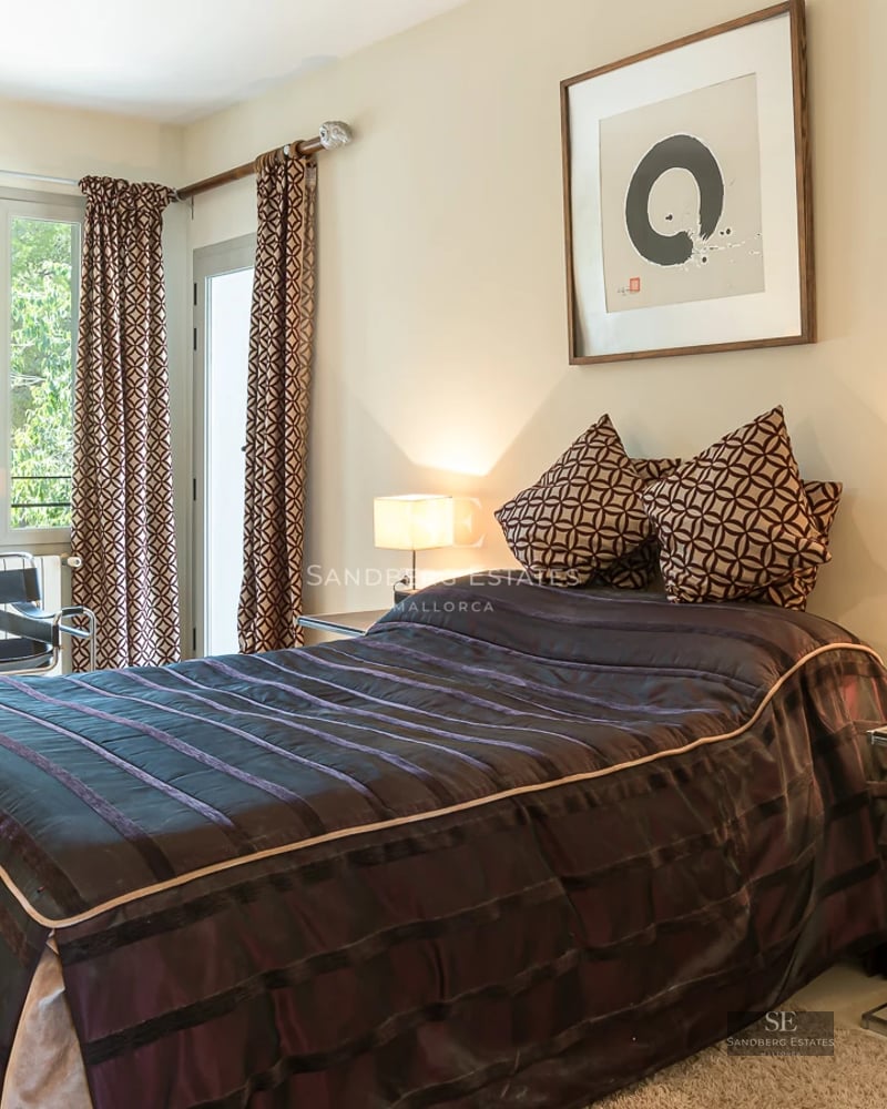 Spacious living room featuring panoramic windows, designer sofa, and fireplace. Elegant decor, terrace access with views. Design lighting.